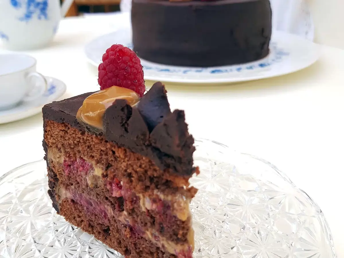 Corte de torta de chocolate con frambuesas y manjar