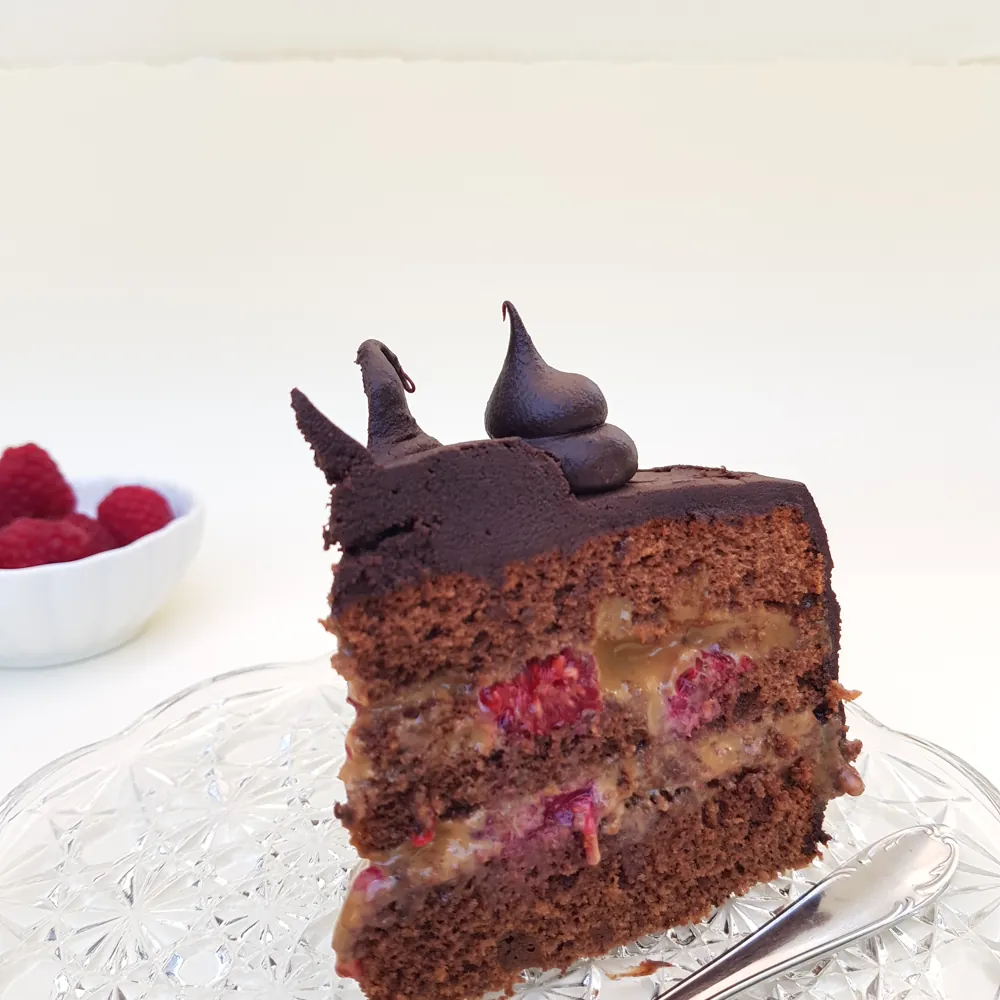 Torta de chocolate decorada con frambuesas y manjar